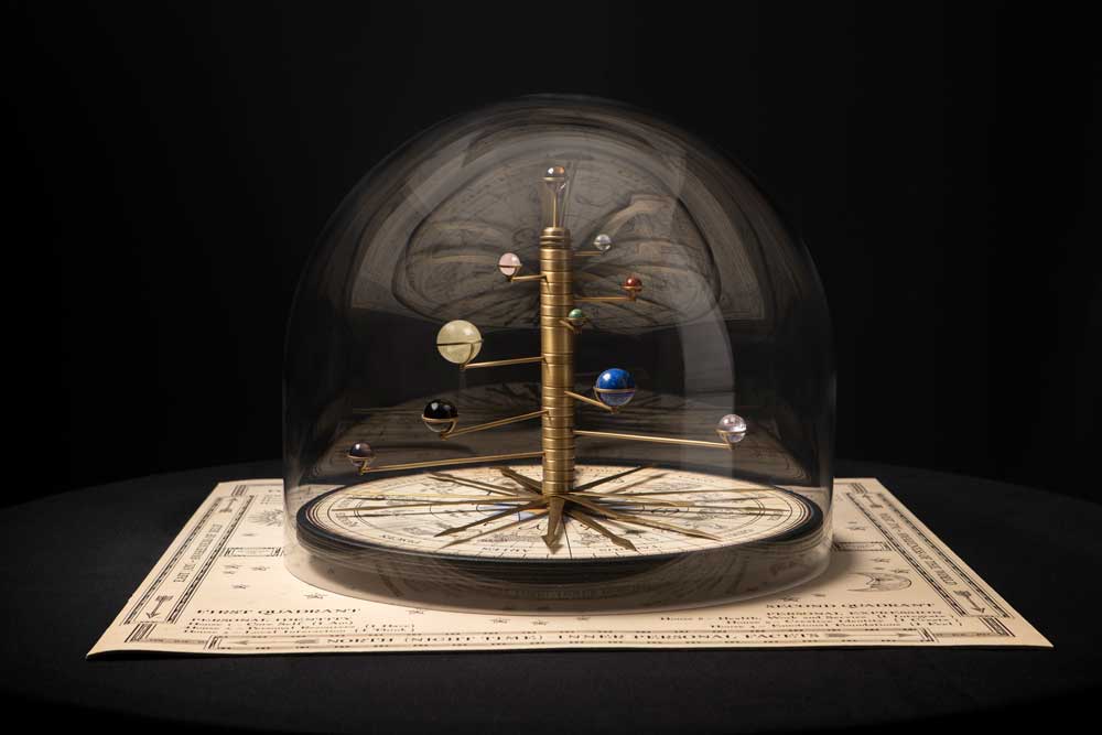 This is an image of Nosti Antiquarian, an antique-looking 3D Natal Chart (or Birth Chart) that shows the planets of the solar system, zodiac signs and houses of astrology, sitting on a square leather based under a protective glass dome. Nosti Antiquarian 3D Natal Chart is for sale and available to buy.